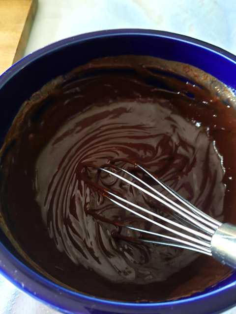 chocolate and cream being mixed until glossy